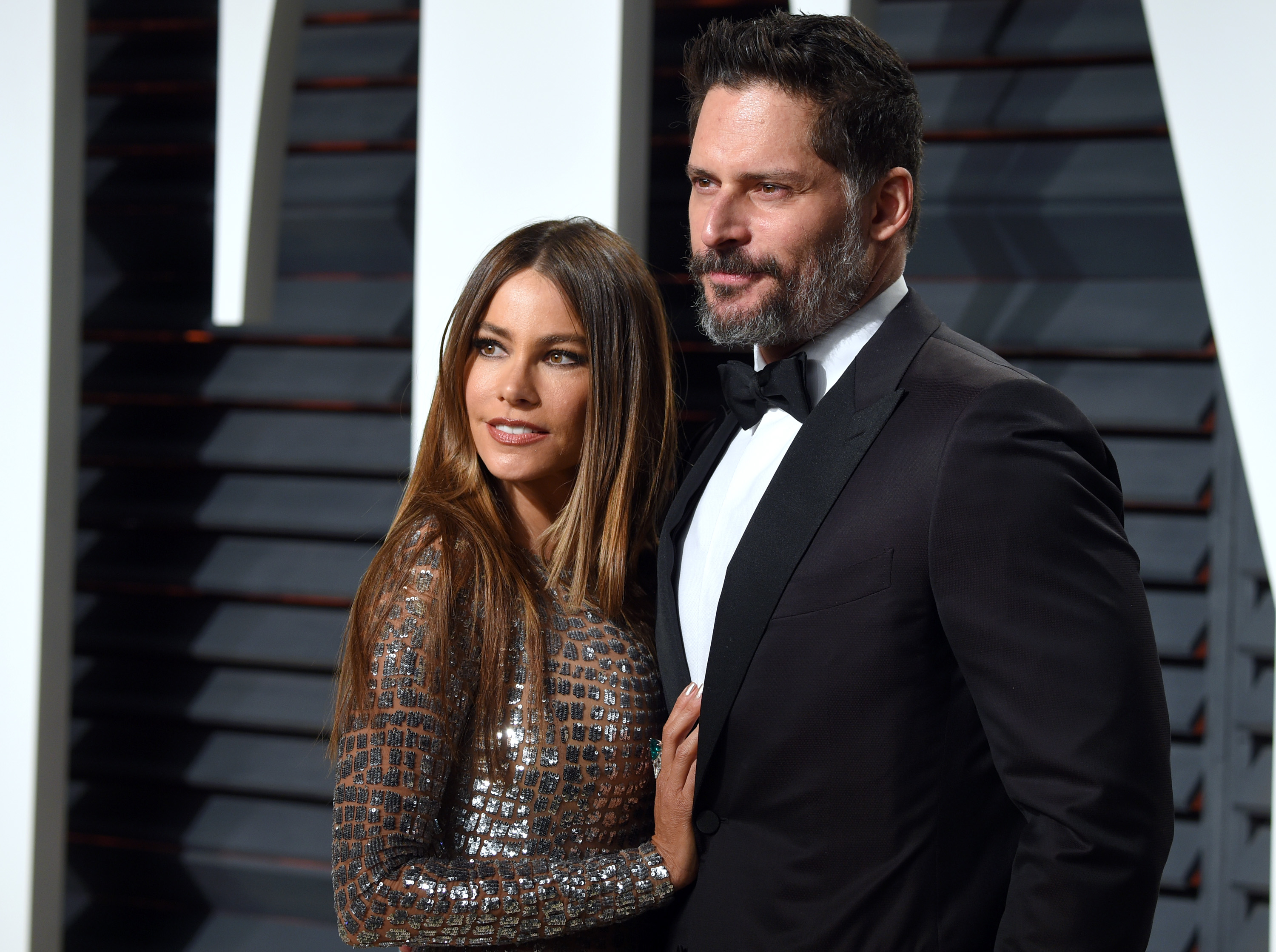 Close-up of Joe in a tuxe and Sofía in a shiny outfit at a media event