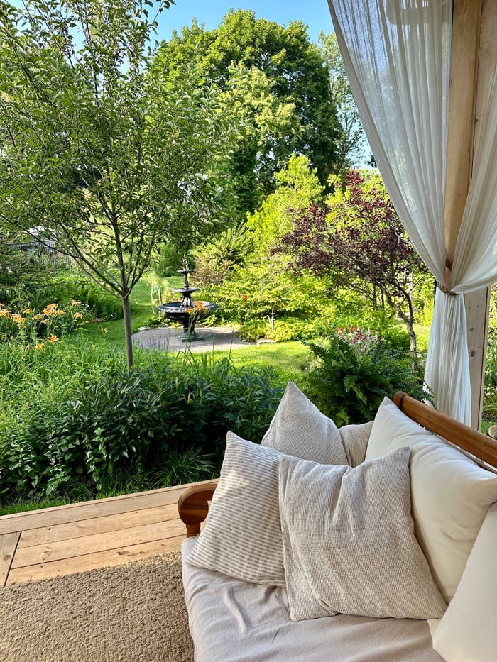 A patio with a couch overlooking gardens