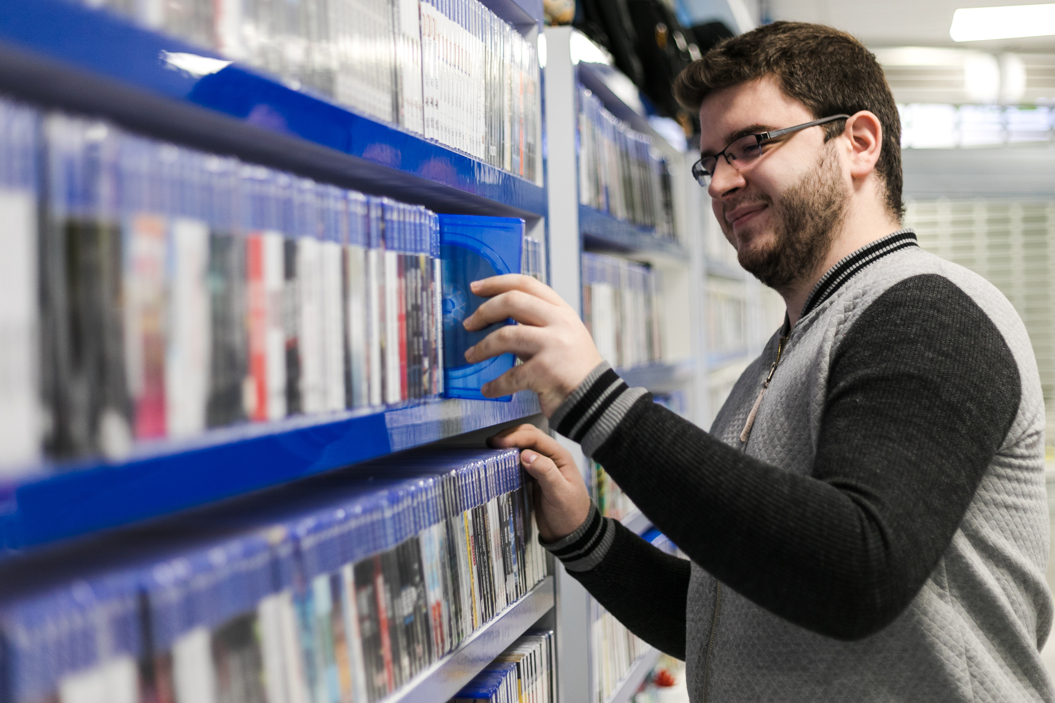 A man putting a game back on the shelf