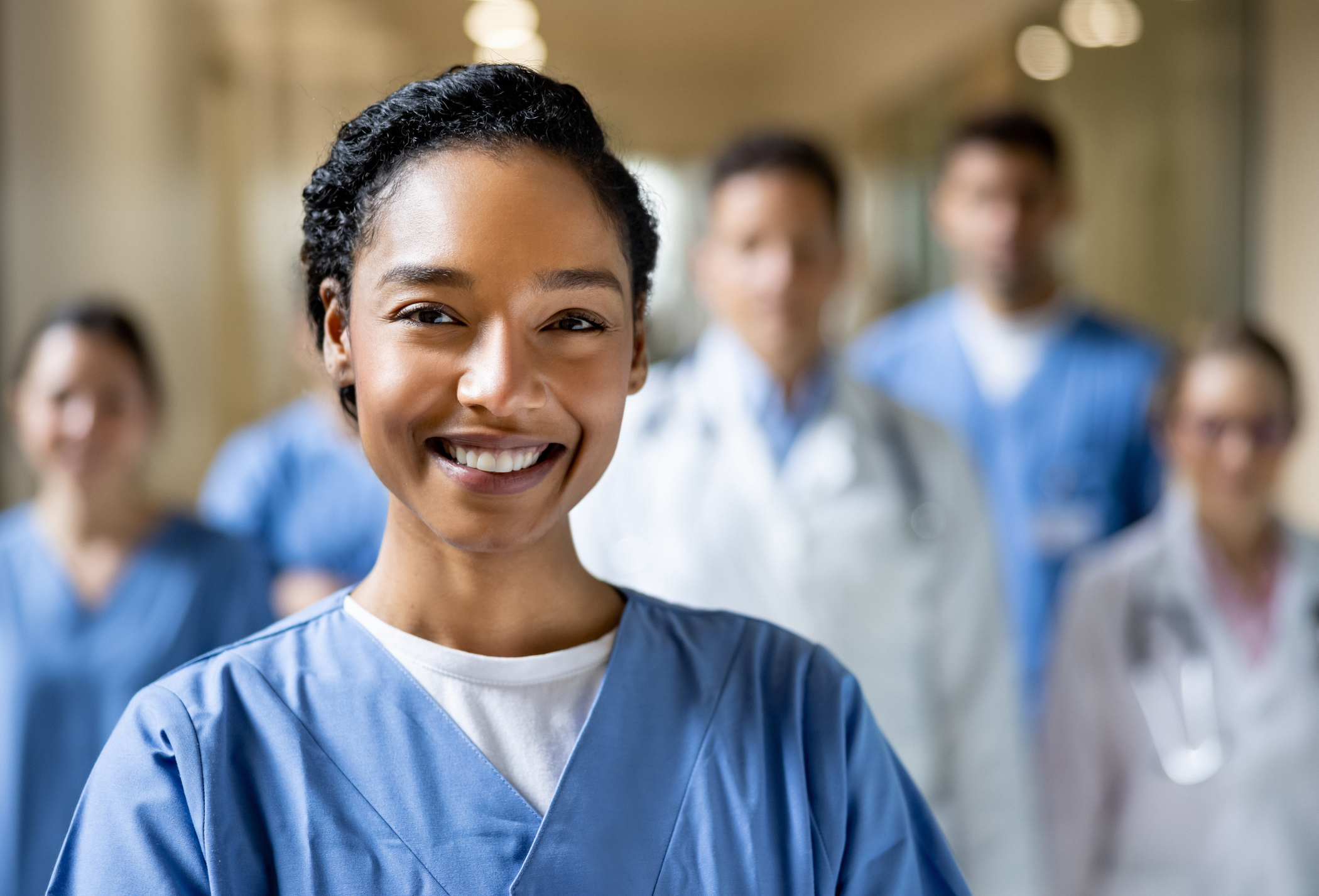 A doctor smiling with other doctors standing behind her