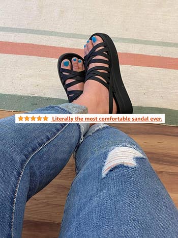 A reviewer wearing the sandals in black with a 5-star review that says 