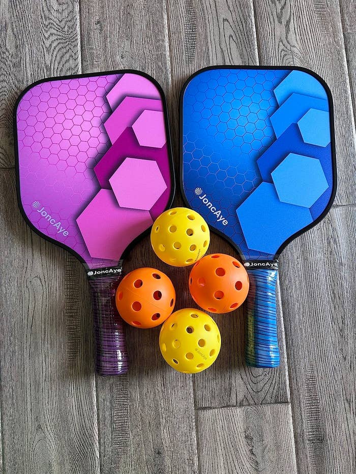 a reviewer&#x27;s image of two paddles and four balls