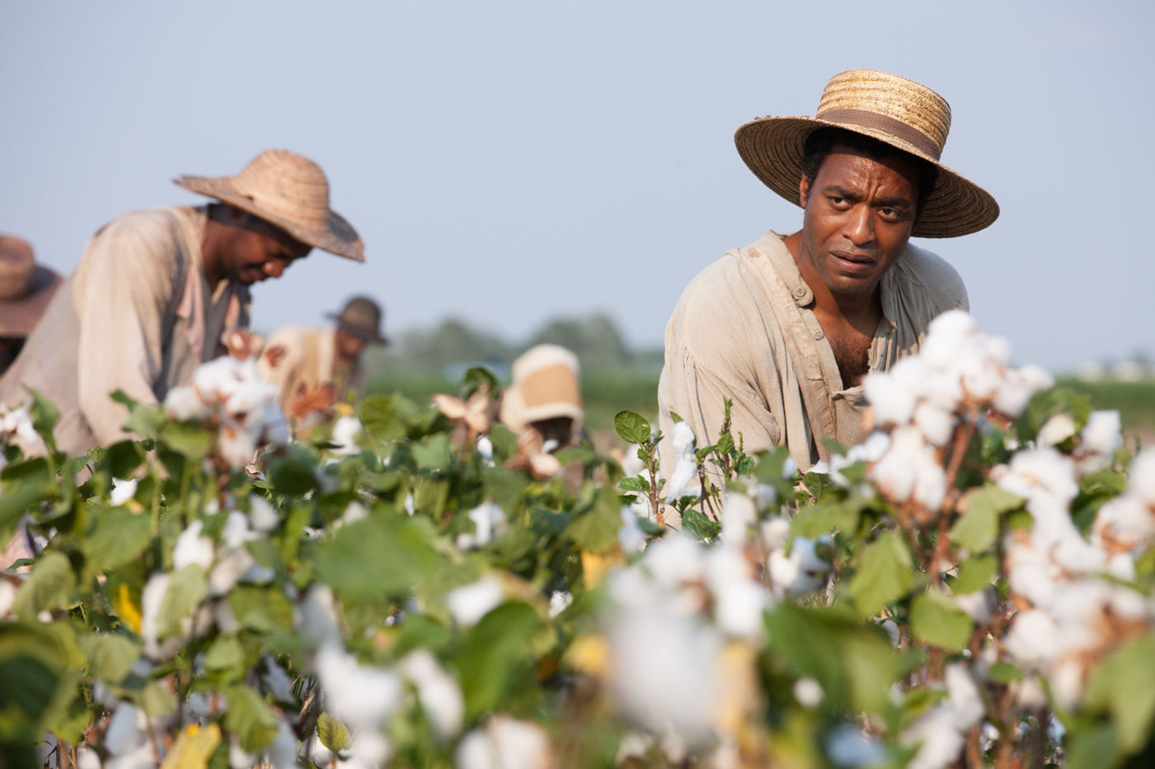 Chiwetel Ejiofor stares with concern while laboring in the glaring sun in a cotton field