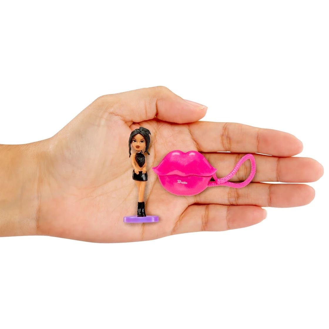 A hand holding a tiny Kylie Bratz doll