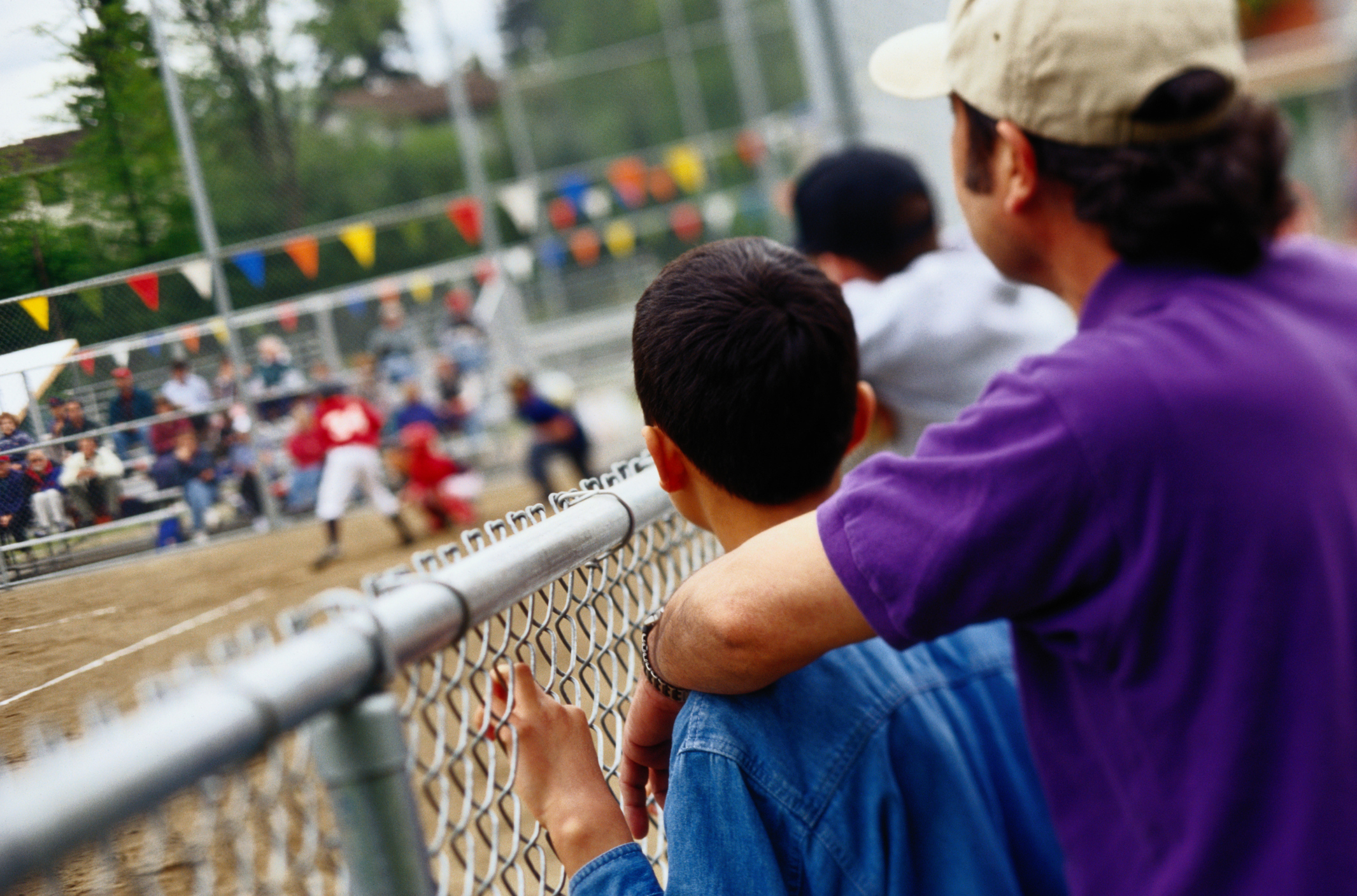 A father and his son are watching a baseball game