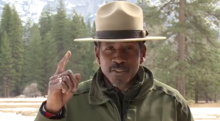 A park ranger with his finger pointing up