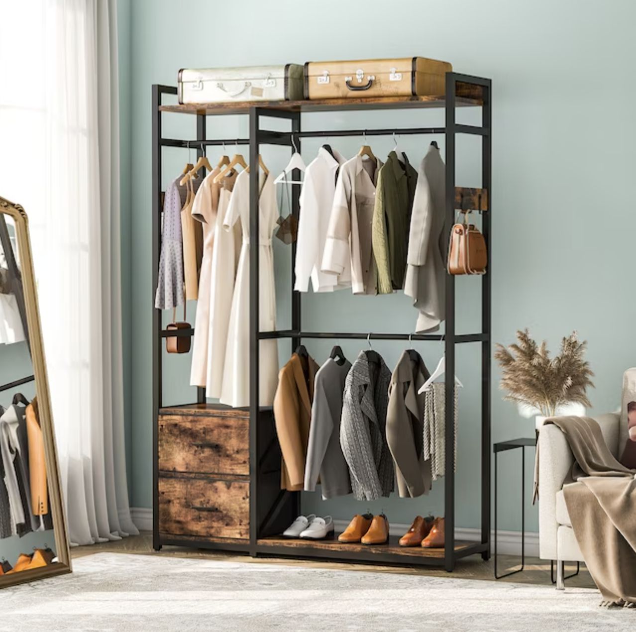 freestanding closet with dresses and jackets hung and shoes and suitcases resting on shelves
