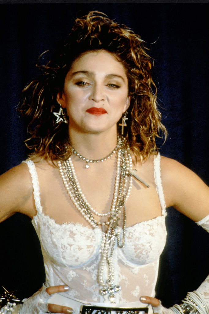 closeup of madonna in a wedding dress and long necklaces