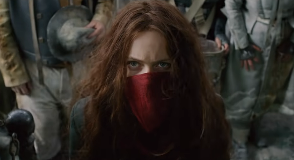 Close-up of Hera Hilmar as Hester wearing a scarf mask