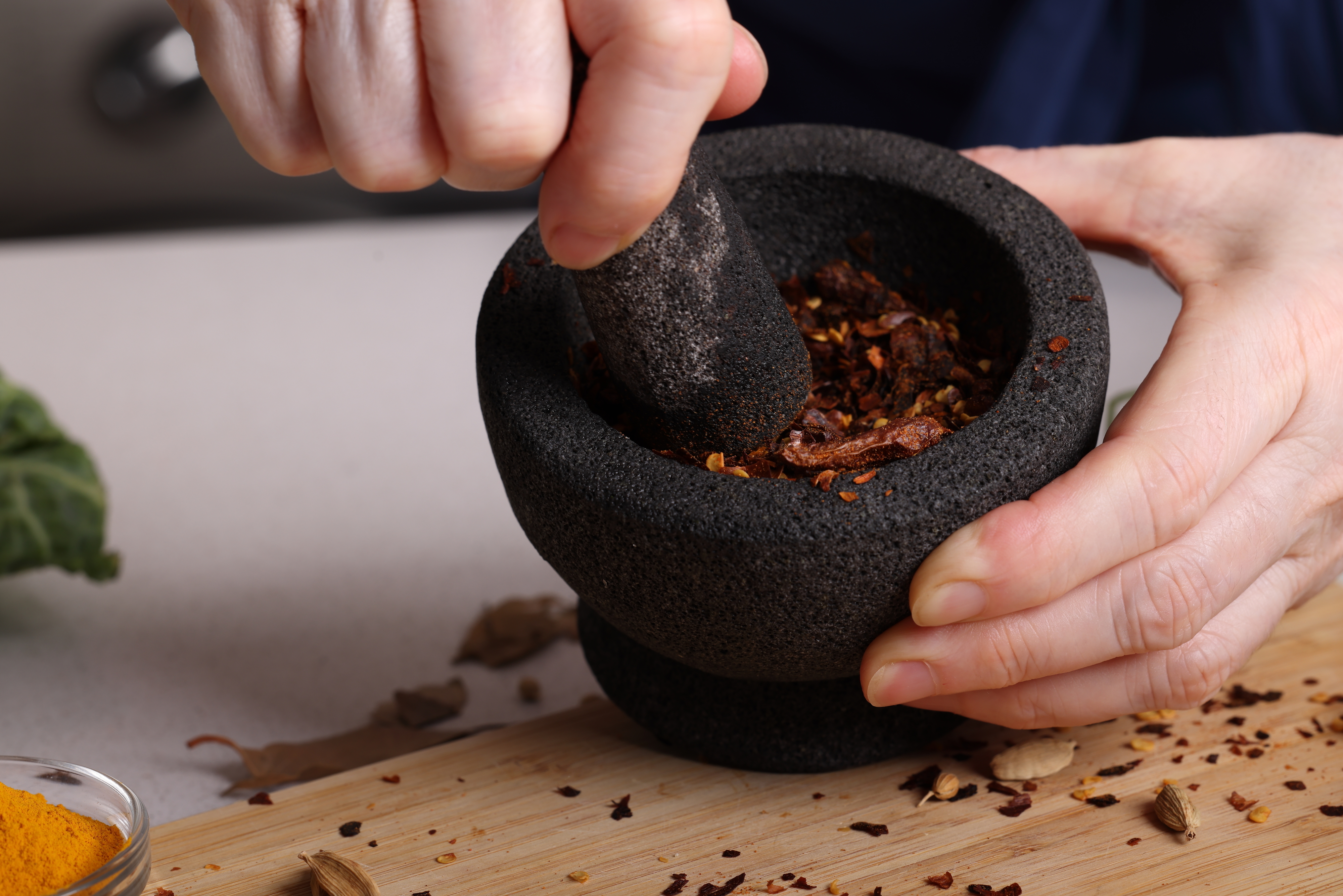 someone crushing spices in a mortar and pestle