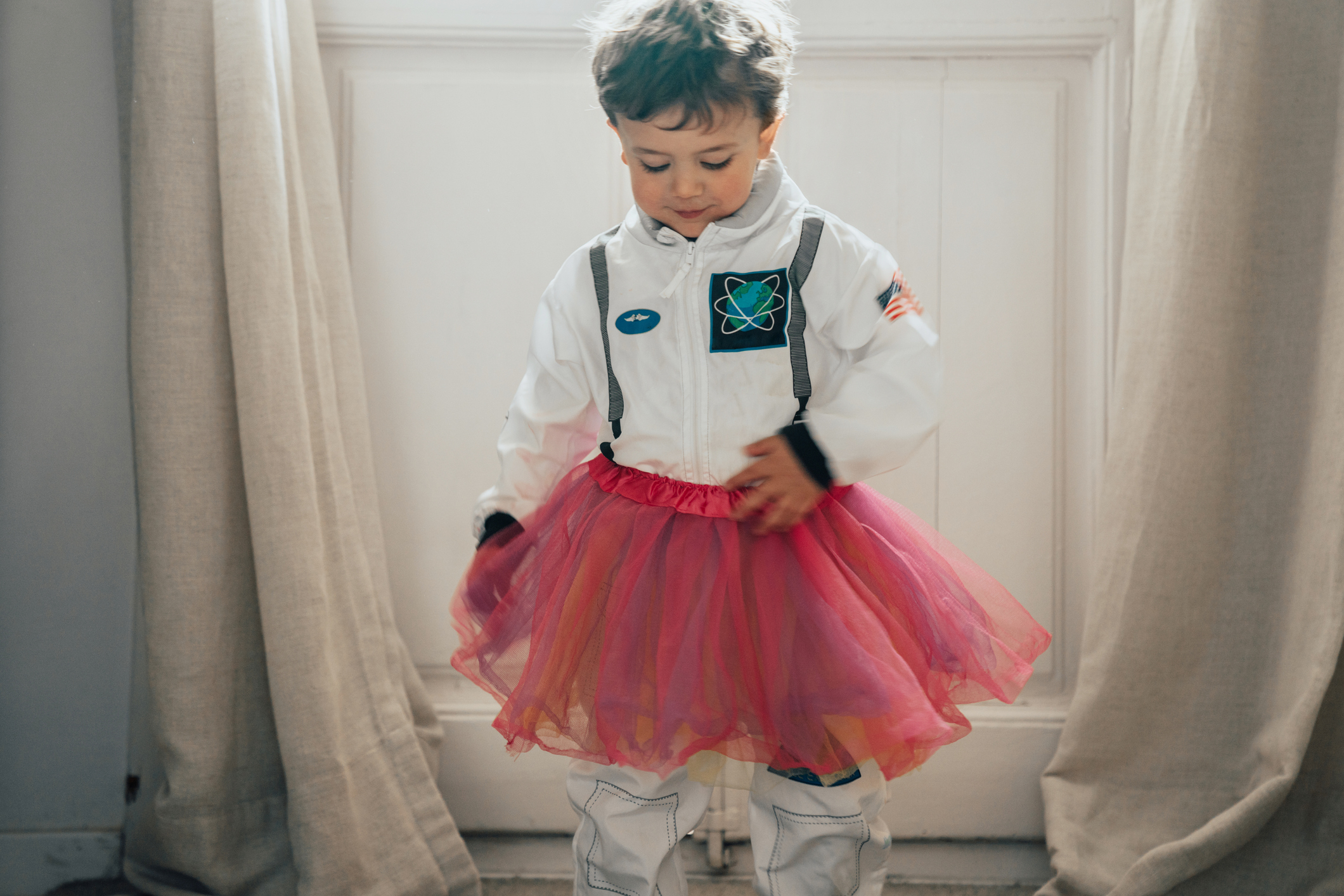 A toddler dressed in a space suit and a tutu