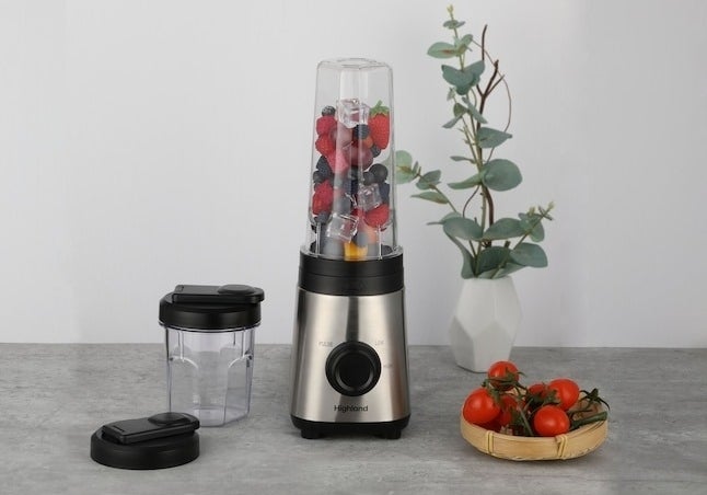 the blender on a counter with berries in it