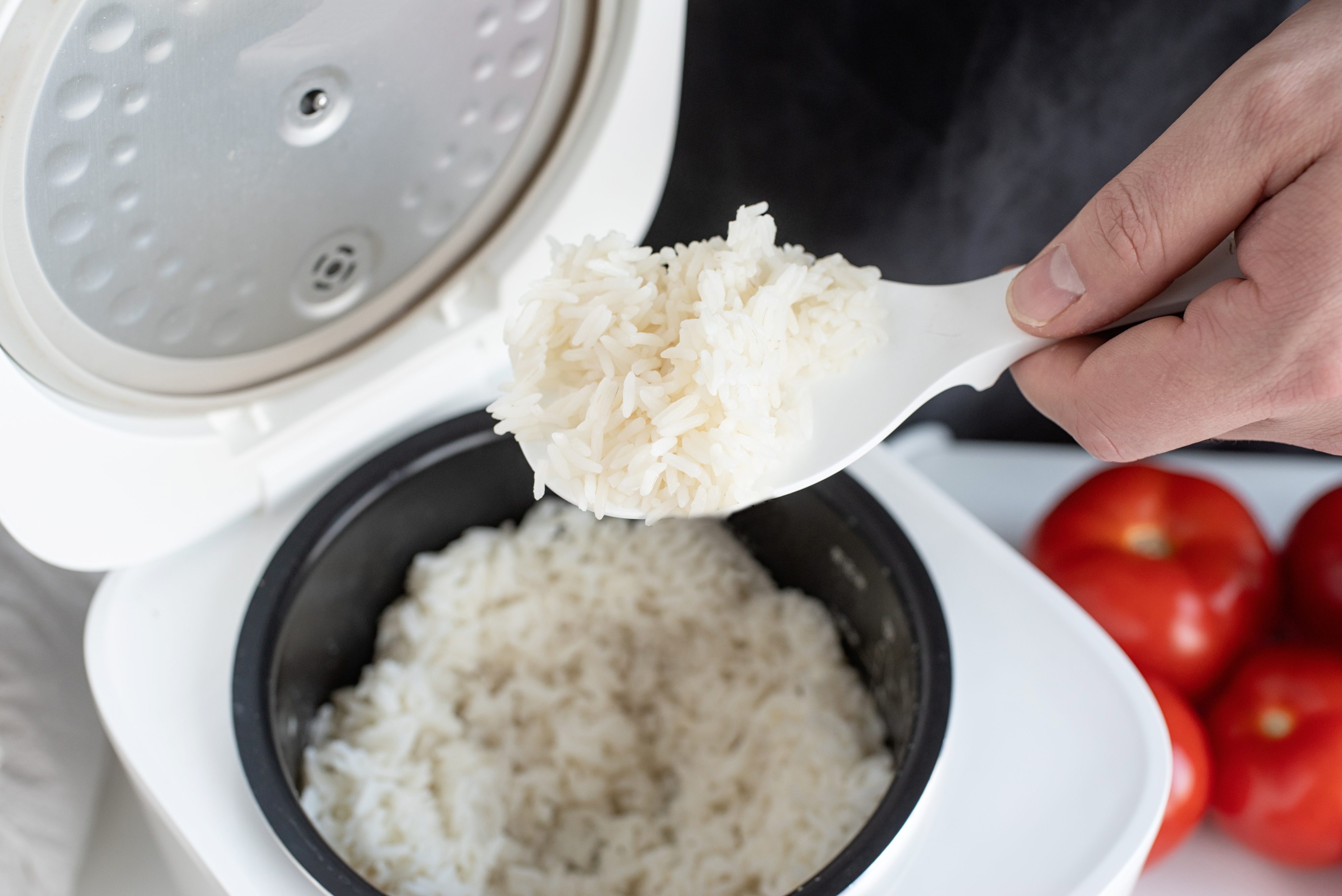 someone spooning rice out of a rice cooker