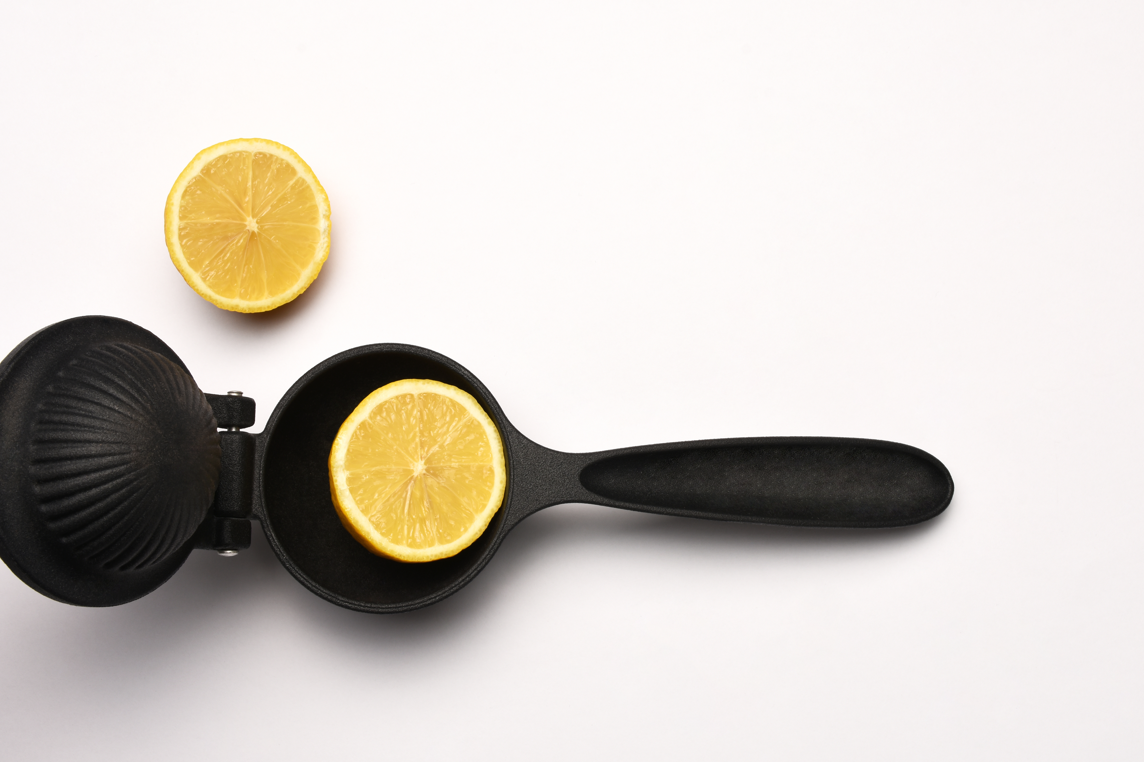 a manual lemon press with a lemon inside