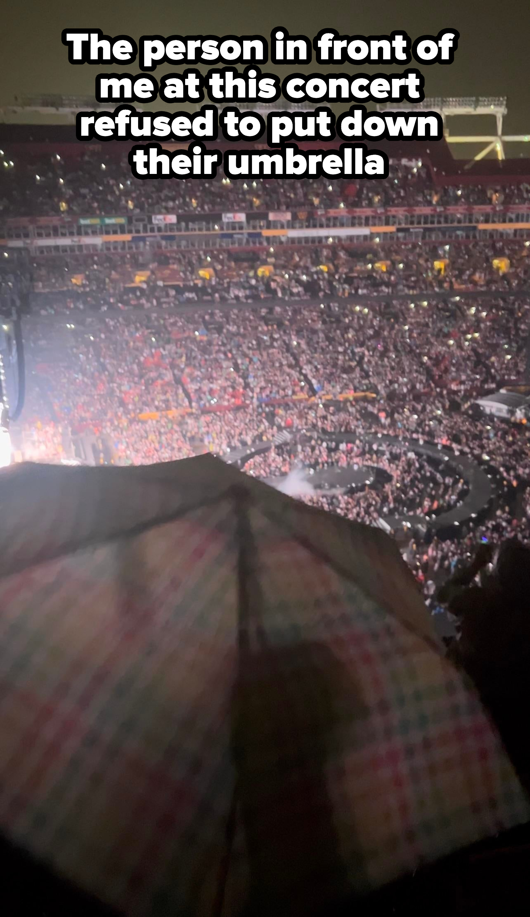 A person whose umbrella is blocking a crowd from seeing a show