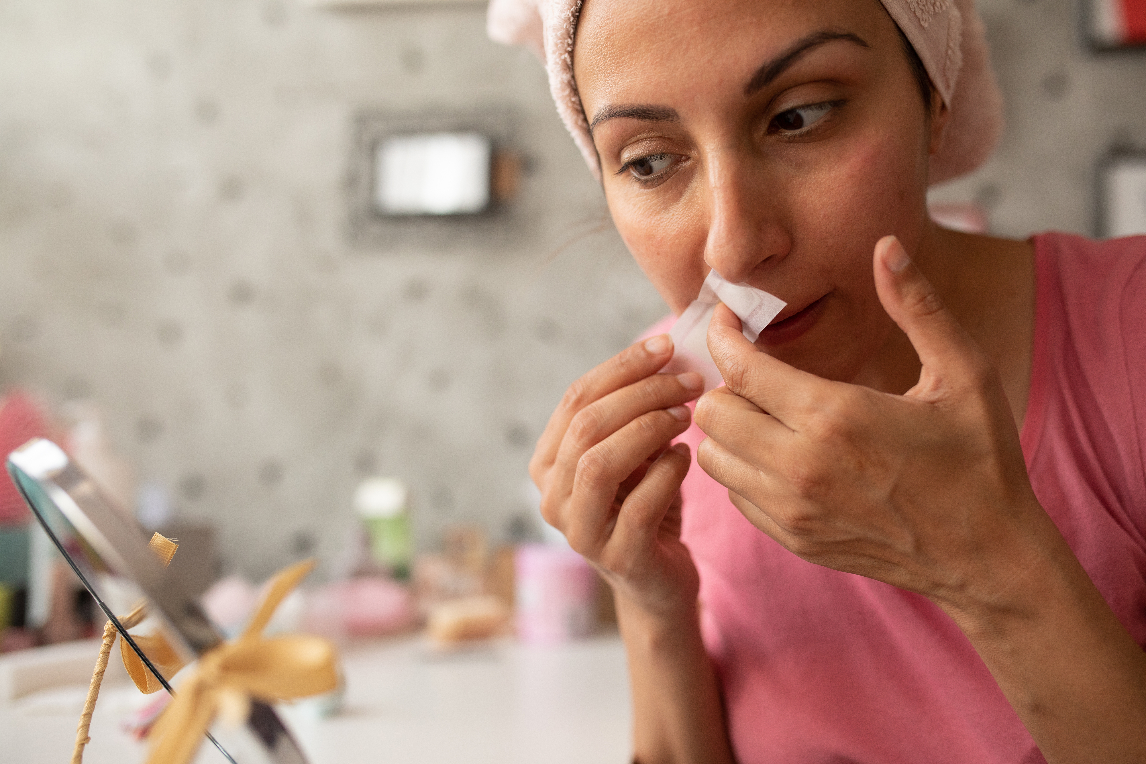 woman waxing her upper lip at home