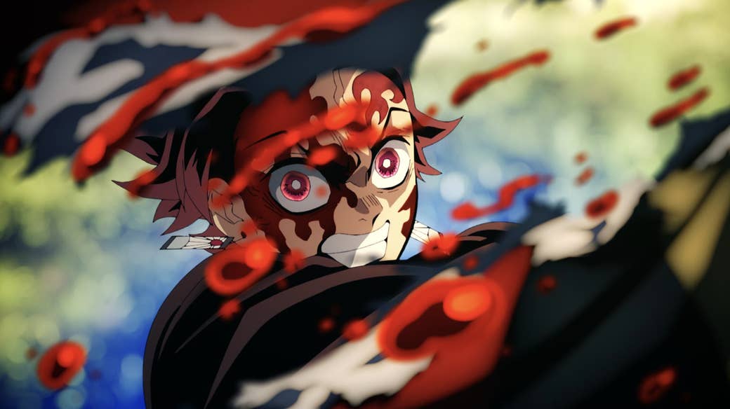 A closeup of Tanjiro using his sword to strike an enemy as blood flies every where