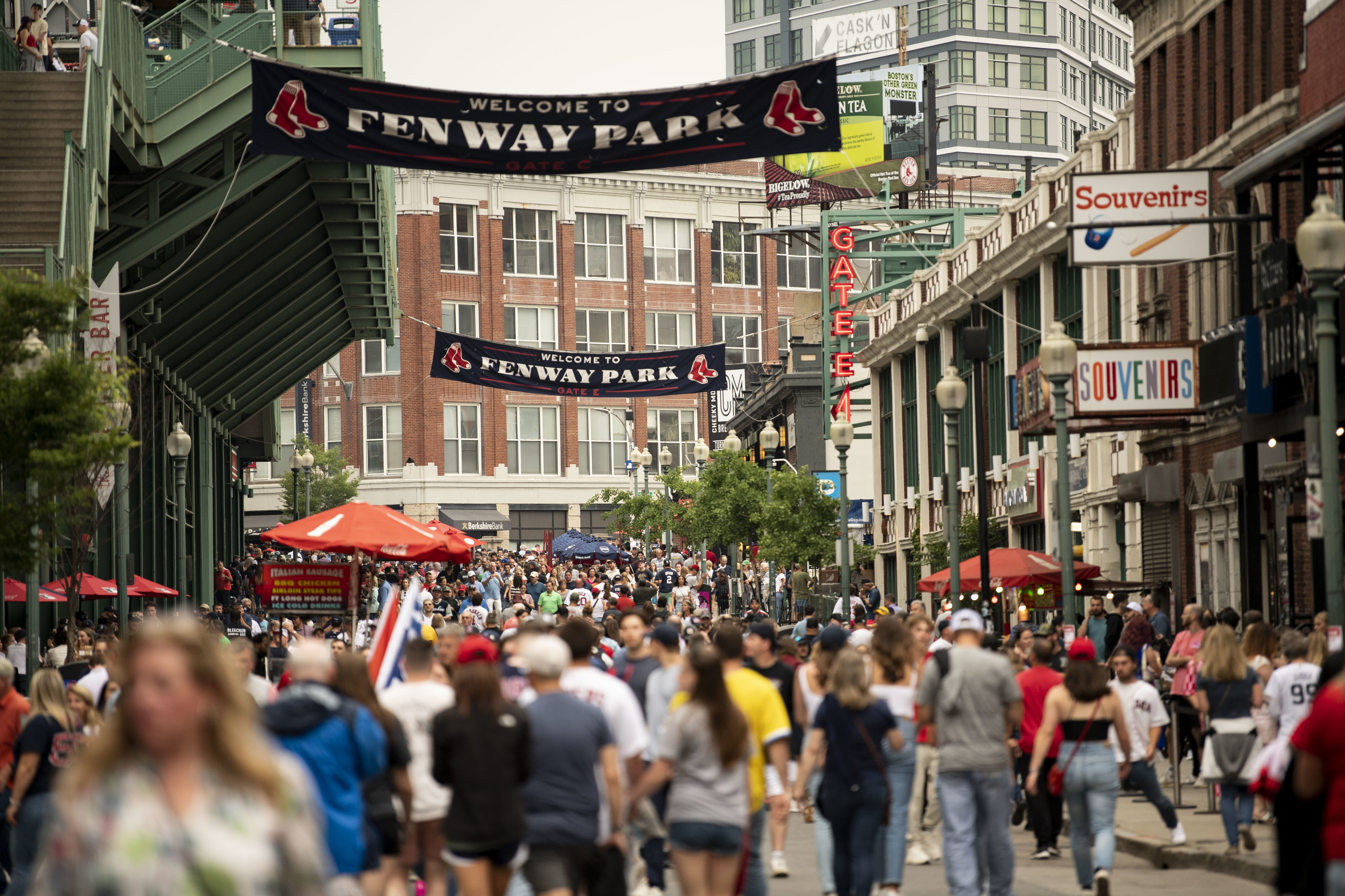 crowded street with people walking near the stadium