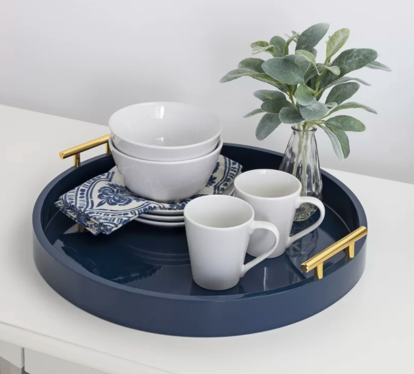 a circular blue dining tray holding white cups and bowls