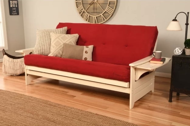 A futon with fold out shelves and red fabric