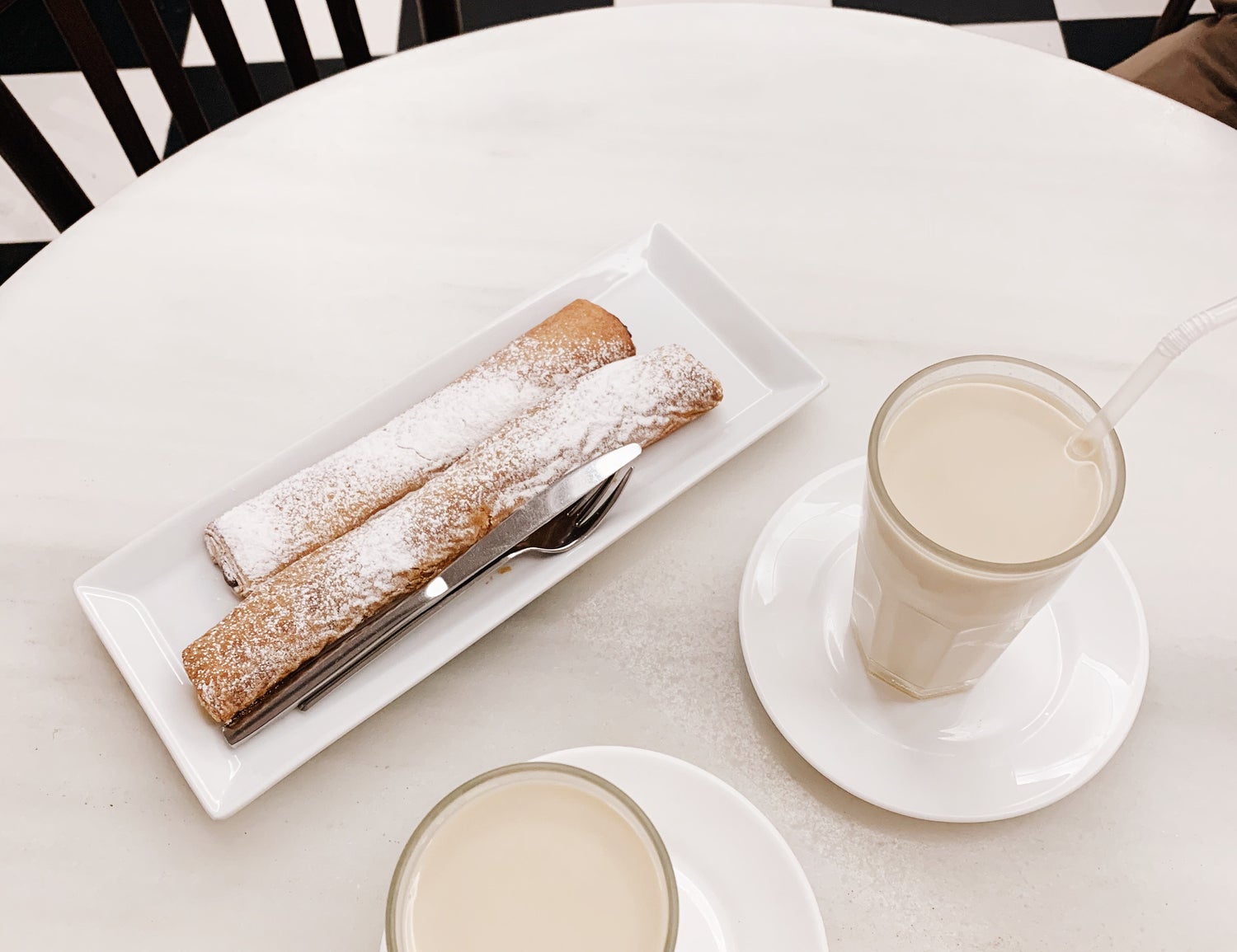 Two glasses of horchata are being served with fartón cake