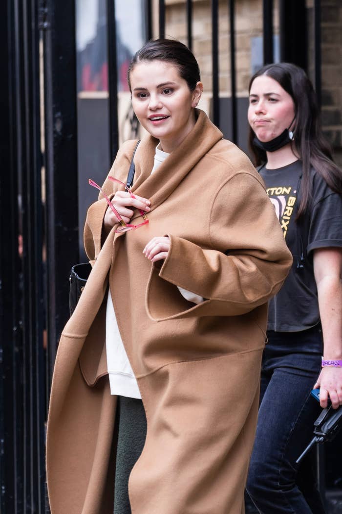 Selena Gomez walking outside wearing a large coat