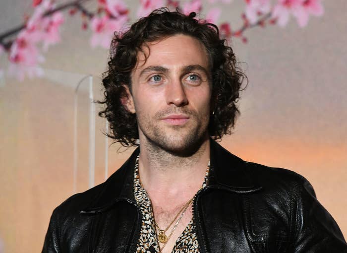 A Close-up of Aaron at a media event in a leather jacket