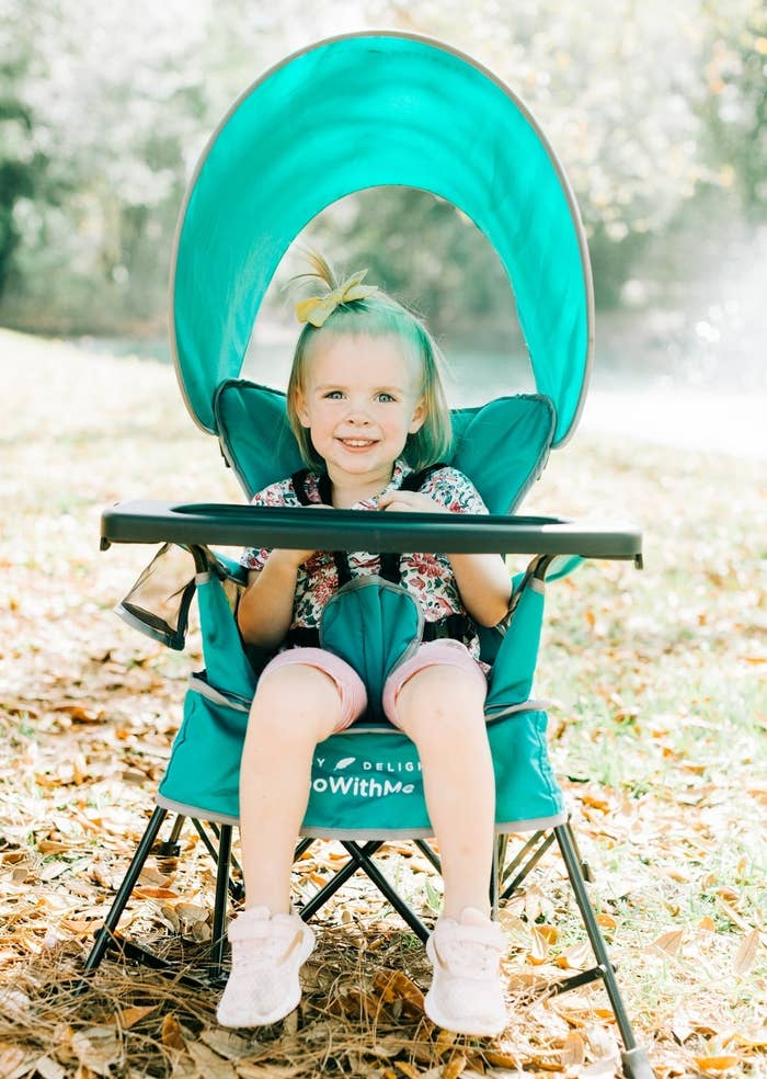 A child in a portable chair outside