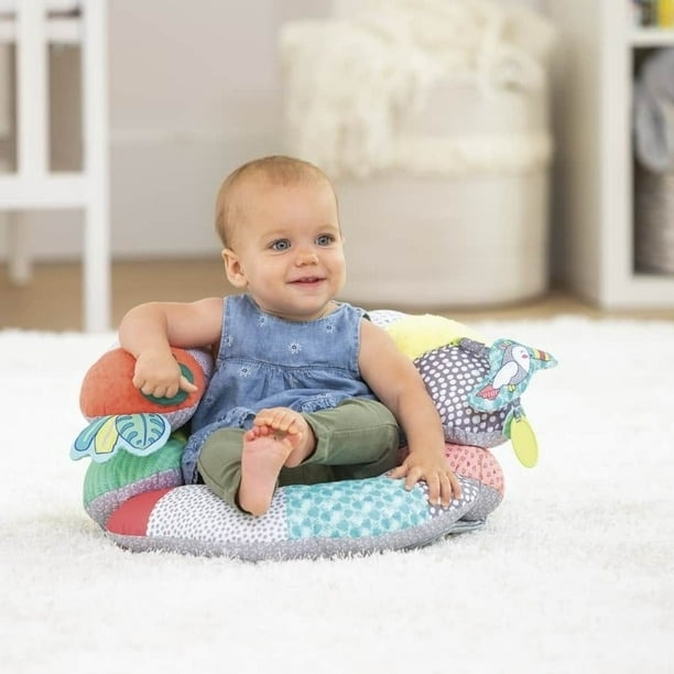 A baby sitting in an infant supporter pillow