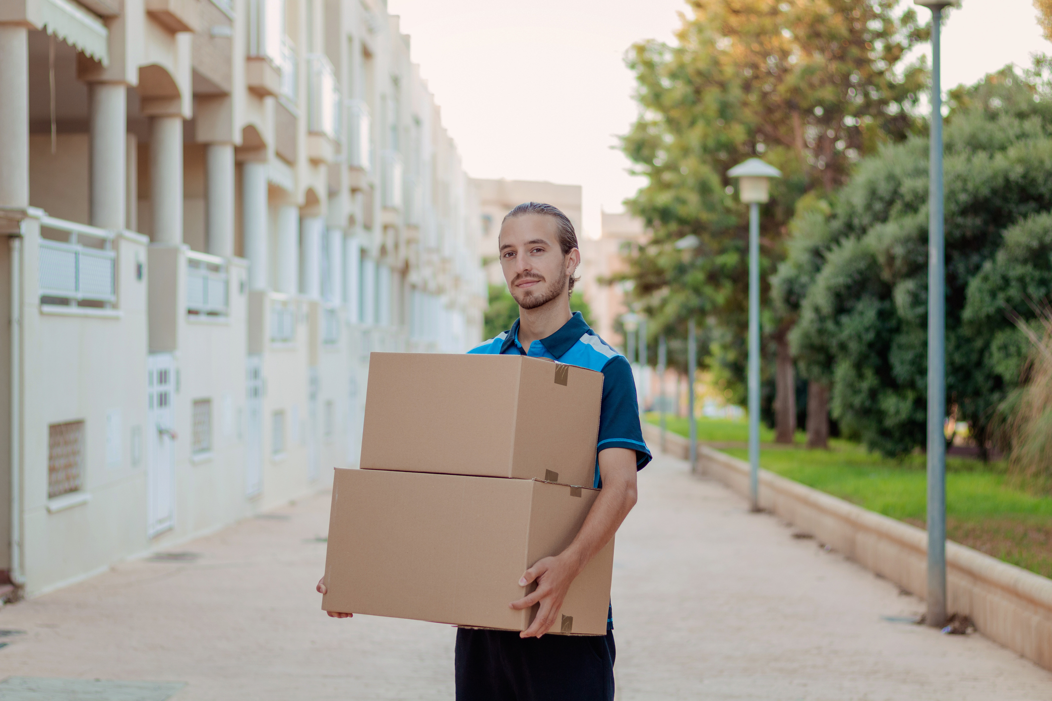 An Amazon delivery worker holding packages