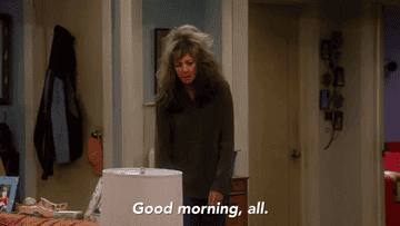 gif of someone with messy hair and tired eyes coming out of a room that reads good morning all