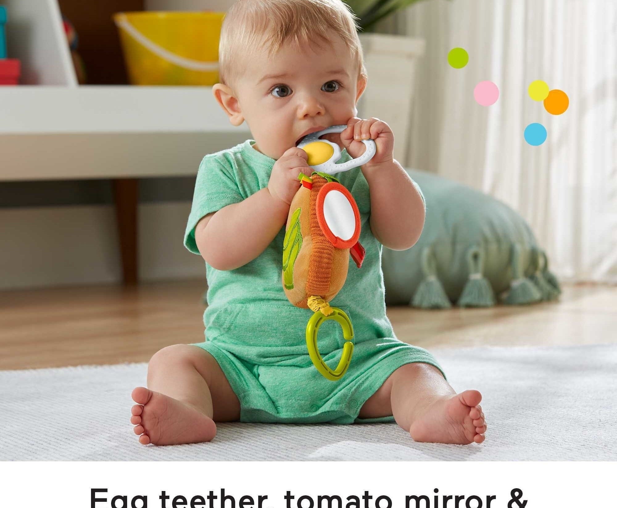 A baby sitting with a teether