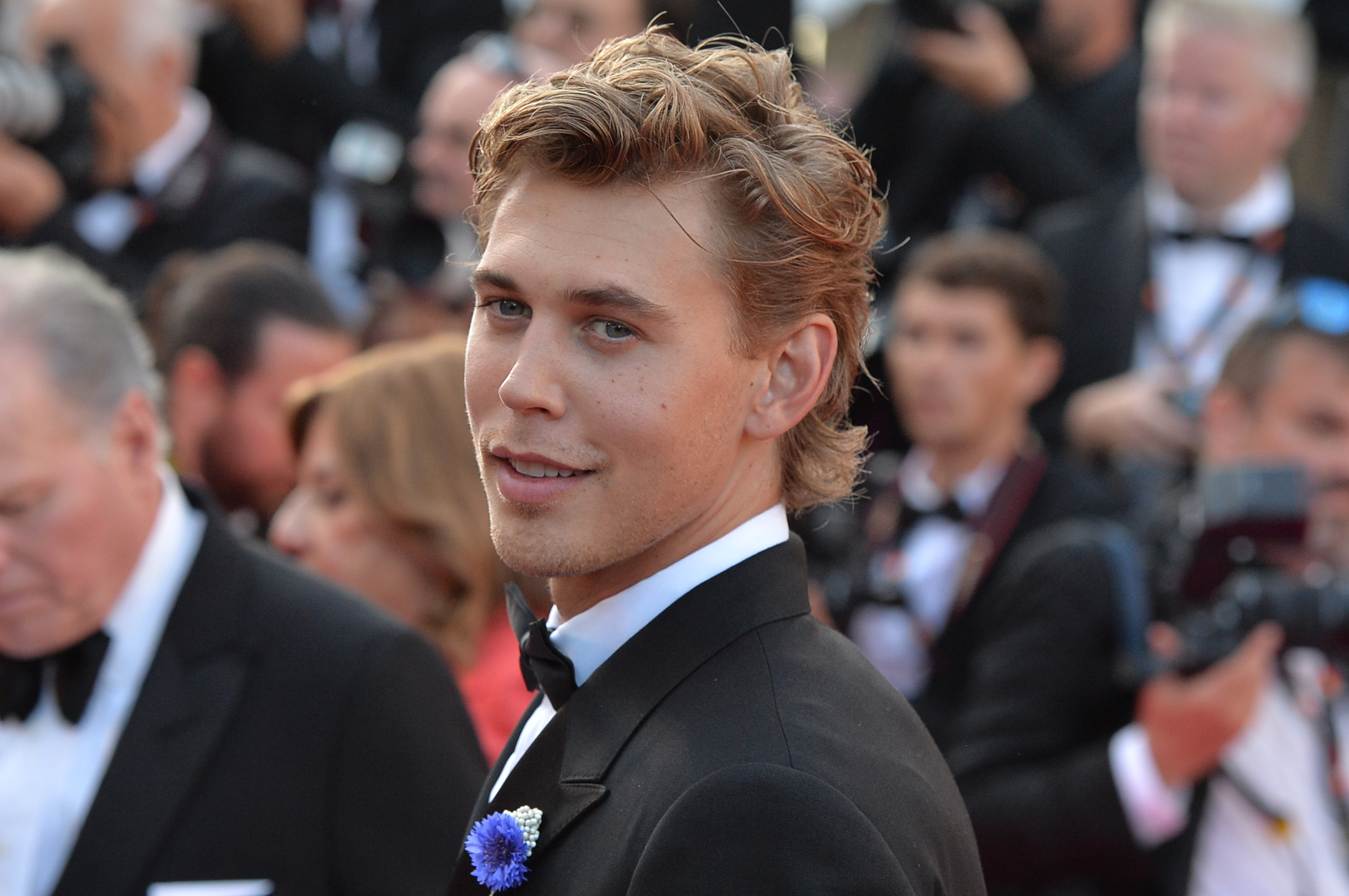 Closeup of Austin Butler on the red carpet with photographers in the background