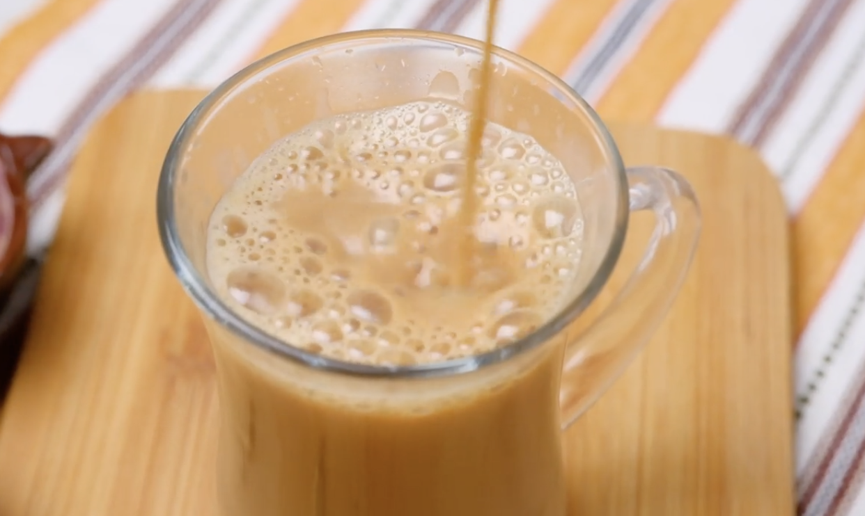 Karak chai is being poured into a glass