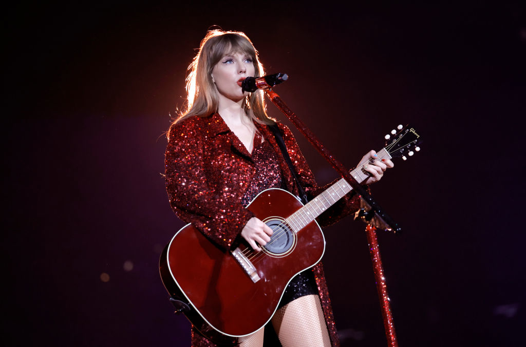 Taylor Swift onstage singing and playing the guitar