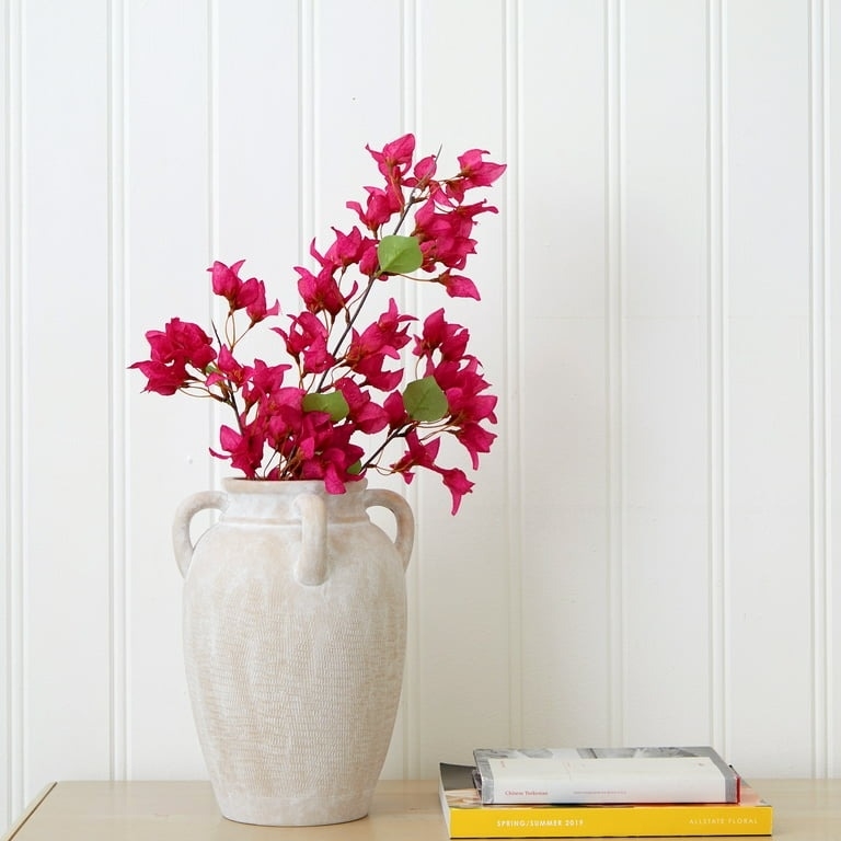 the textured ceramic vase with pink flowers on a table