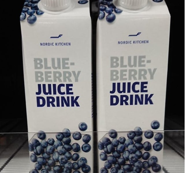 Two cartons of blueberry juice are on the shelf of a grocery store