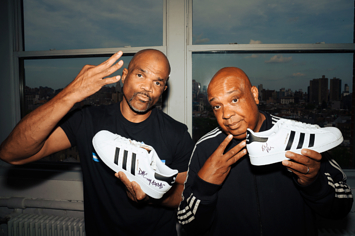 Run and DMC from Run-DMC holding signed pairs of the Adidas Superstar
