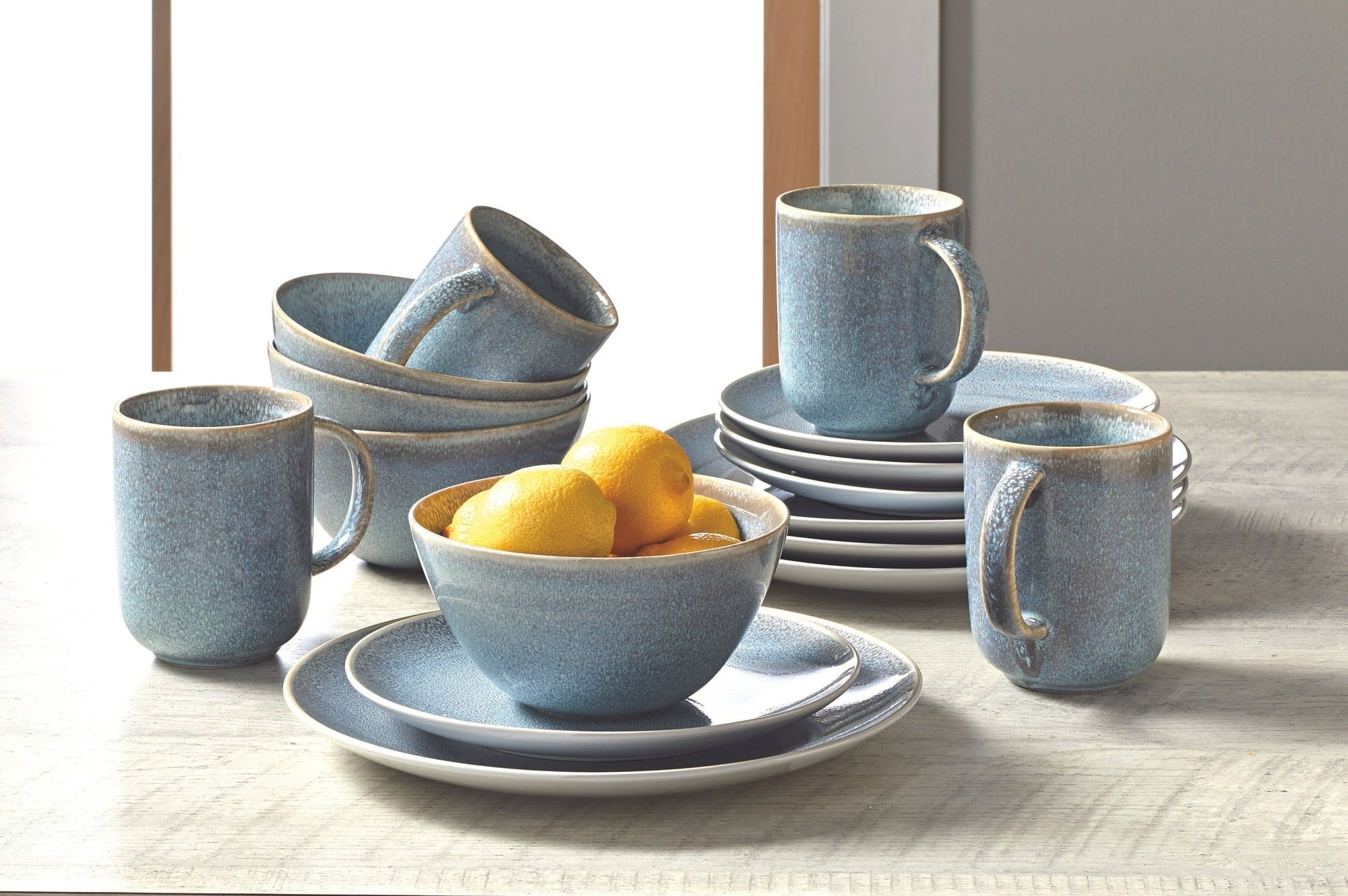 a blue set of mugs, bowls, and plates