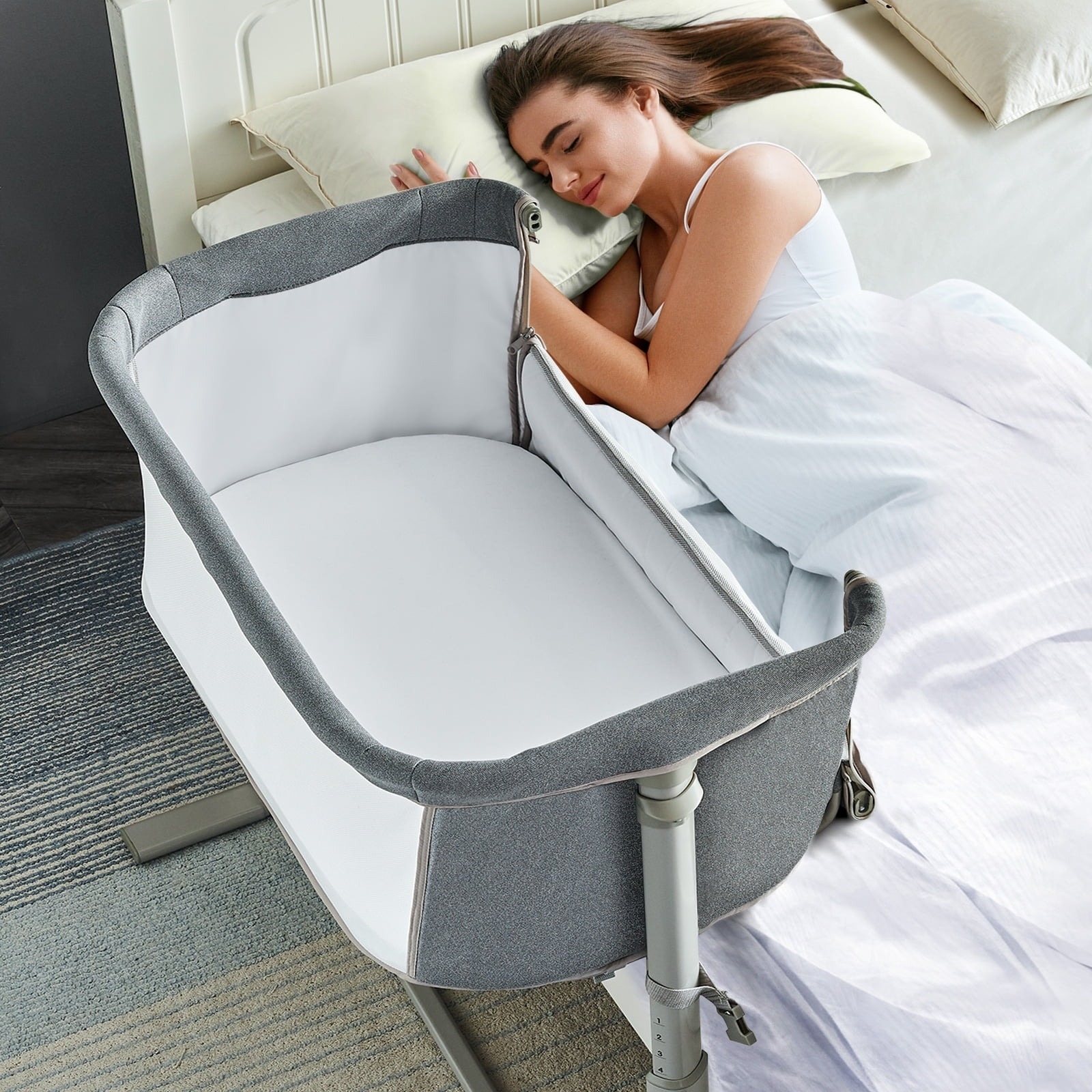 a model sleeping in bed next to the unzippered bassinet