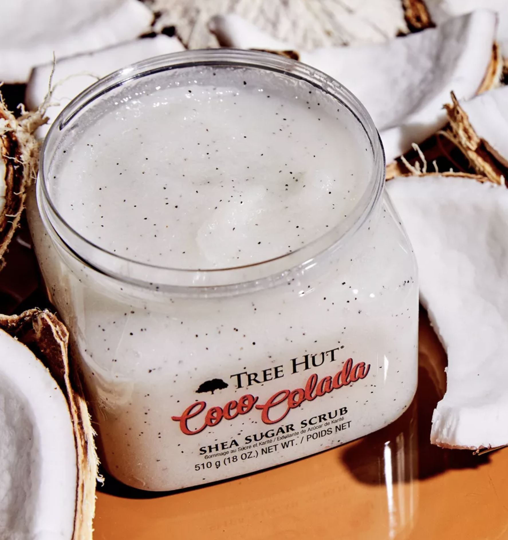 the coco colada body scrub surrounded by coconuts