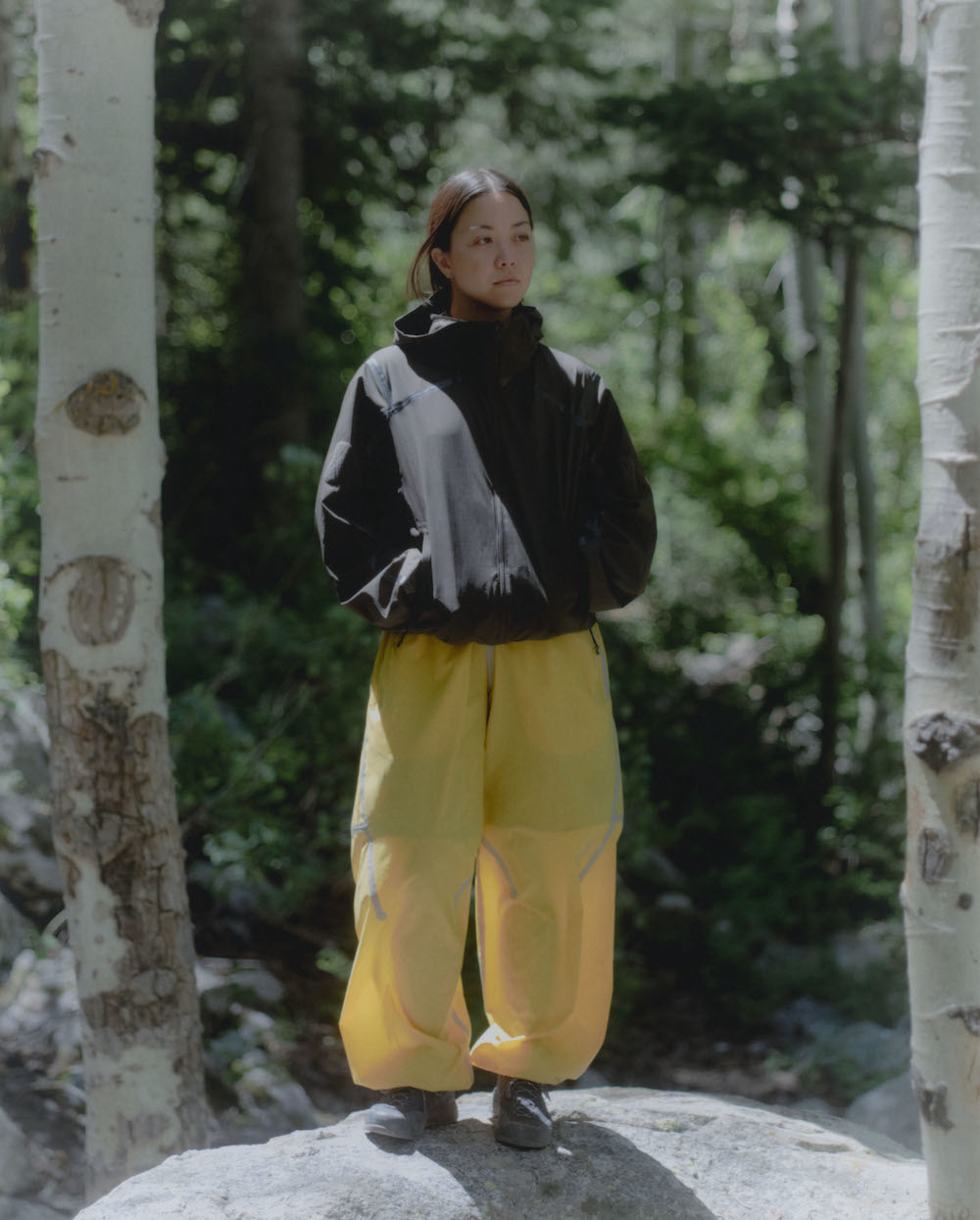 A model wears a black jacket with yellow pants from Arc&#x27;teryx&#x27;s System_A Drop 6