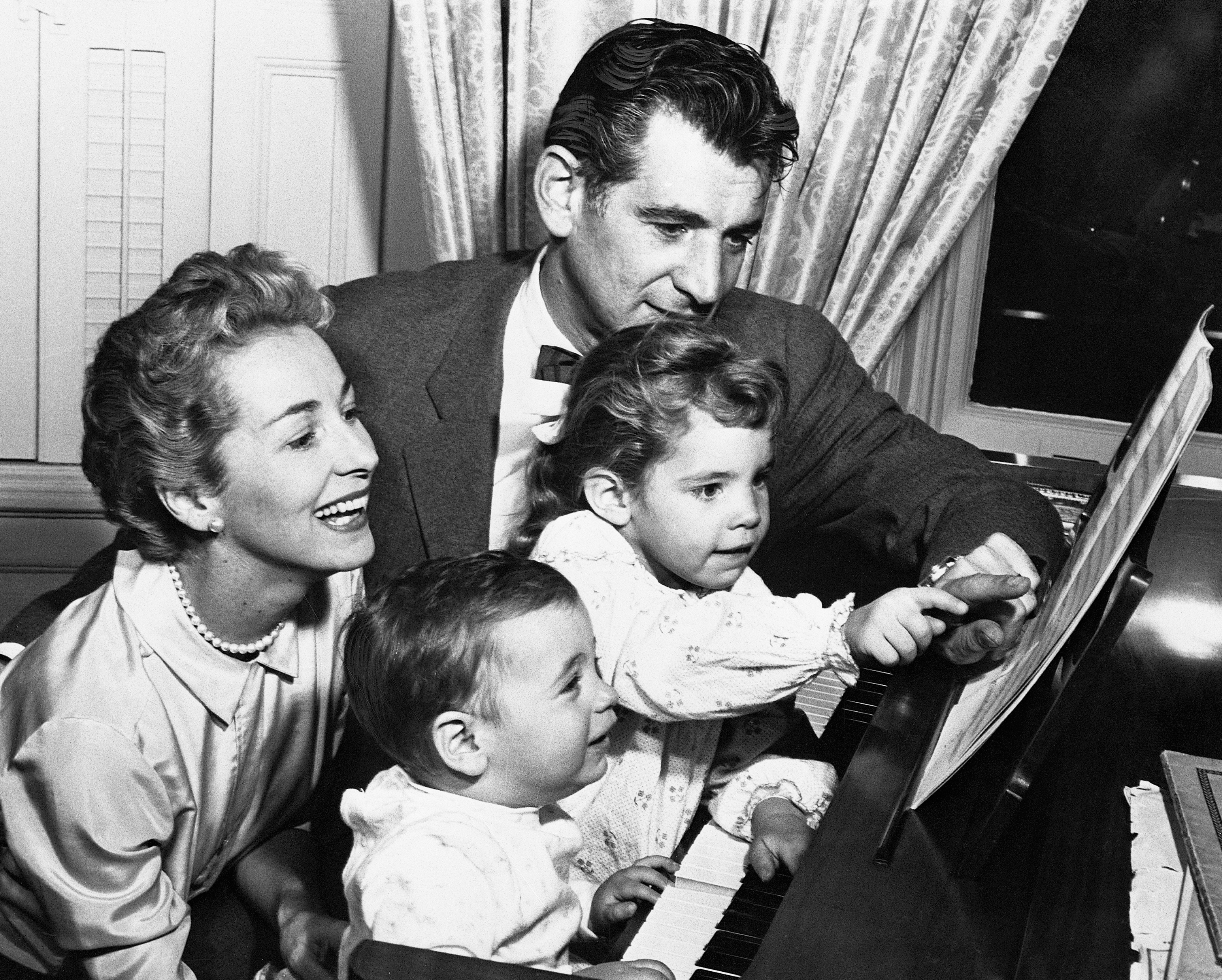 Felicia, Leonard, and two of their children at a piano