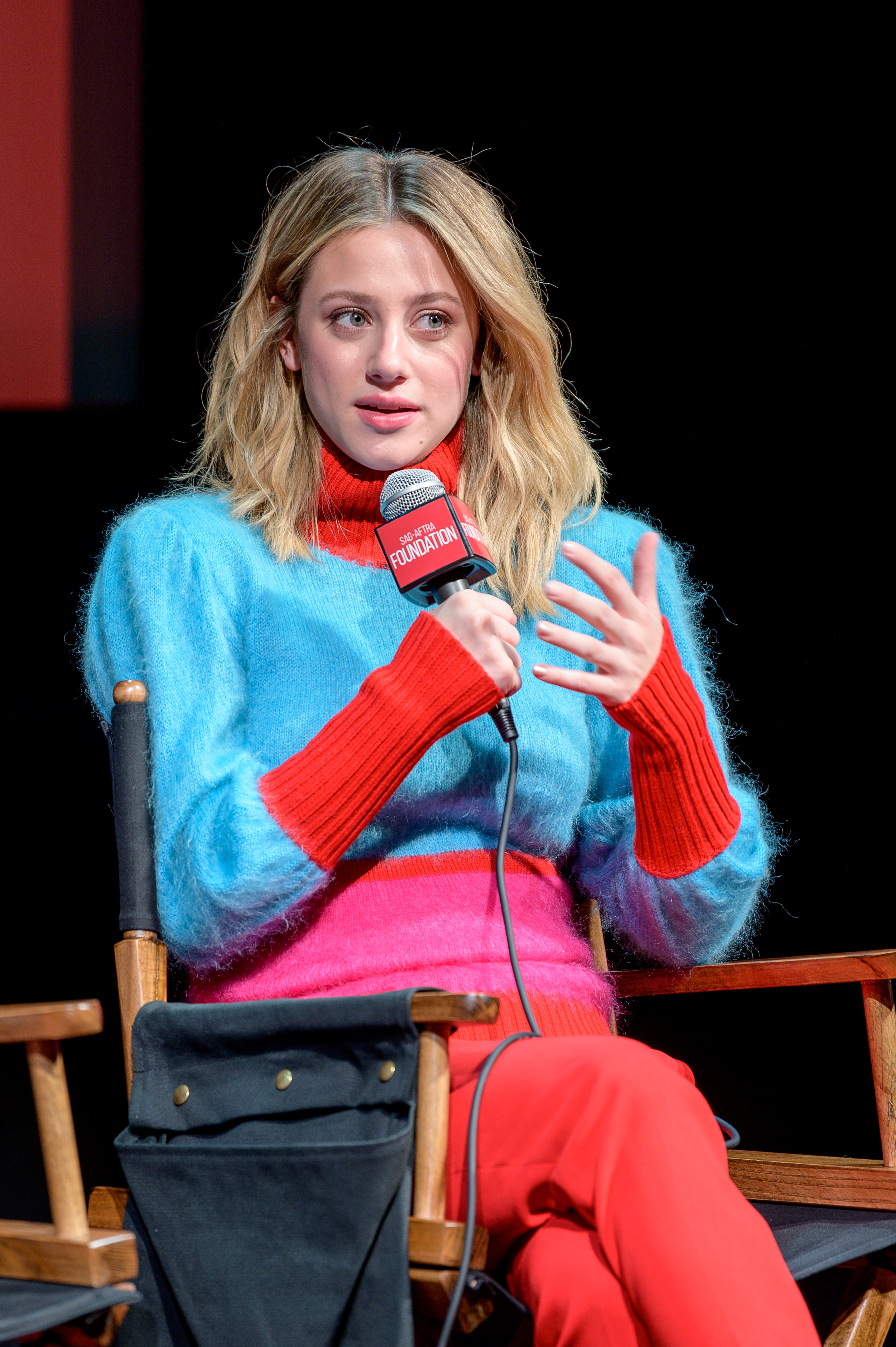 Close-up of Lili sitting and holding a microphone