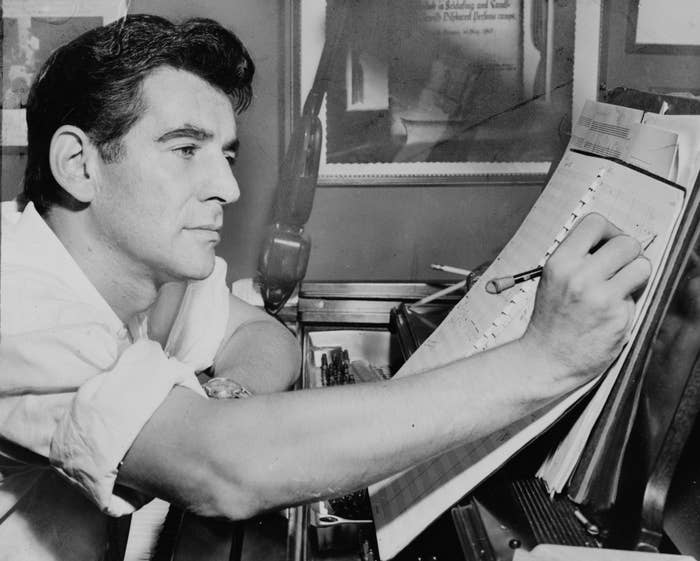 Close-up of Bernstein making notes on a score