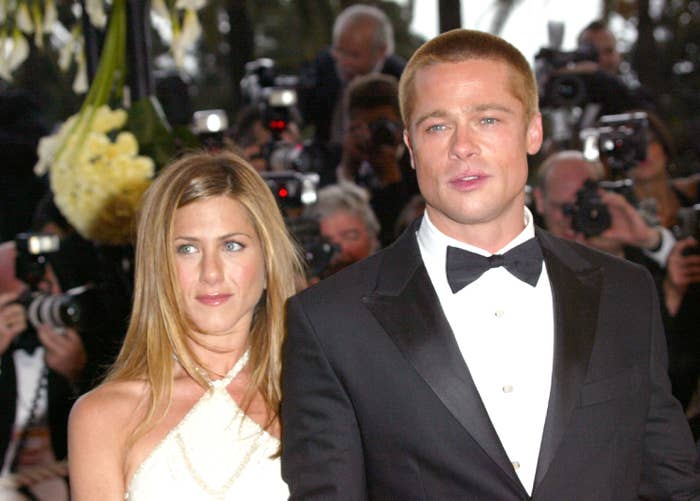 Brad Pitt and Jennifer Aniston on the red carpet with a wall of photographers behind them