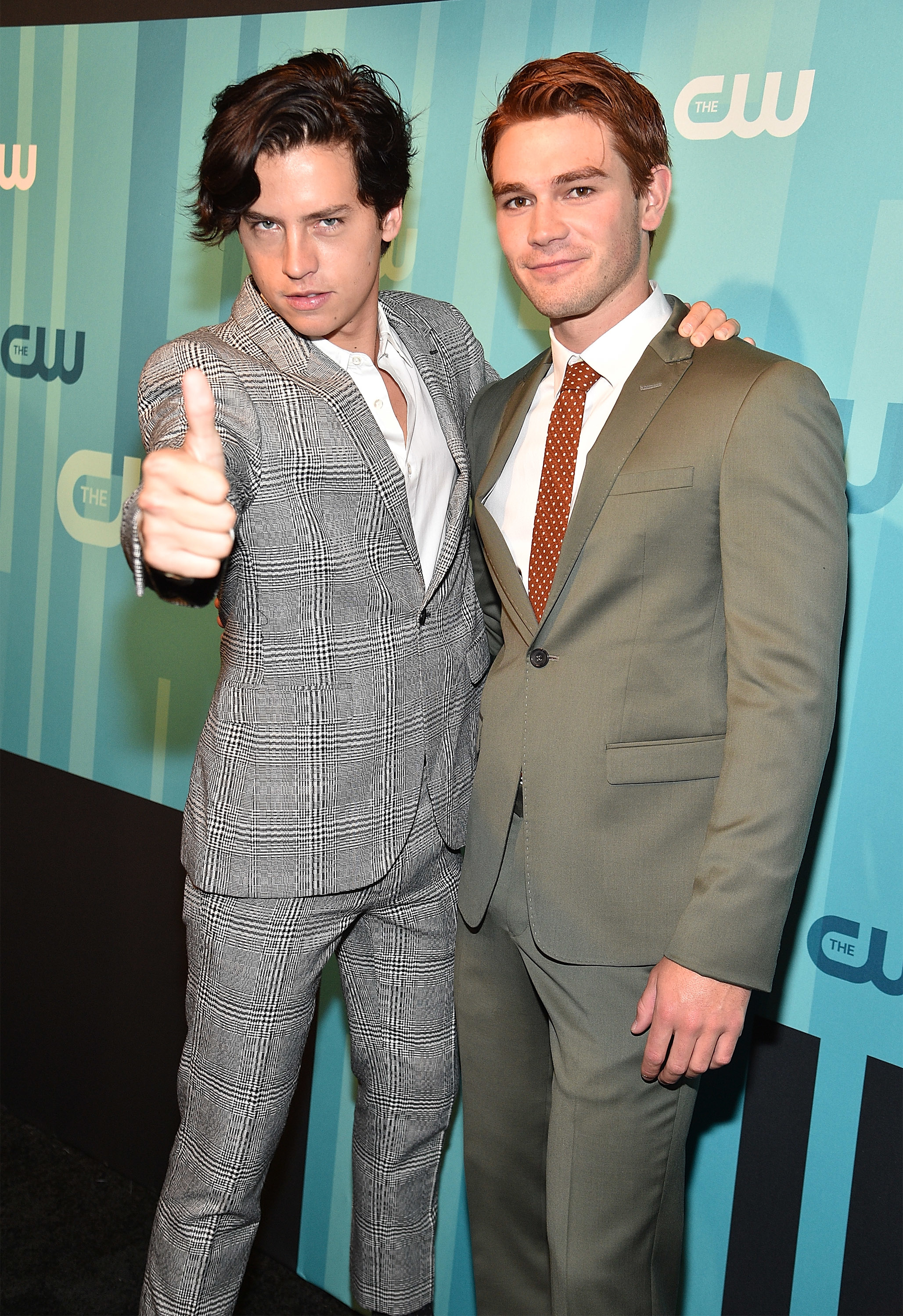 Cole Sprouse gives the thumbs up as he and KJ Apa get their picture taken at an event