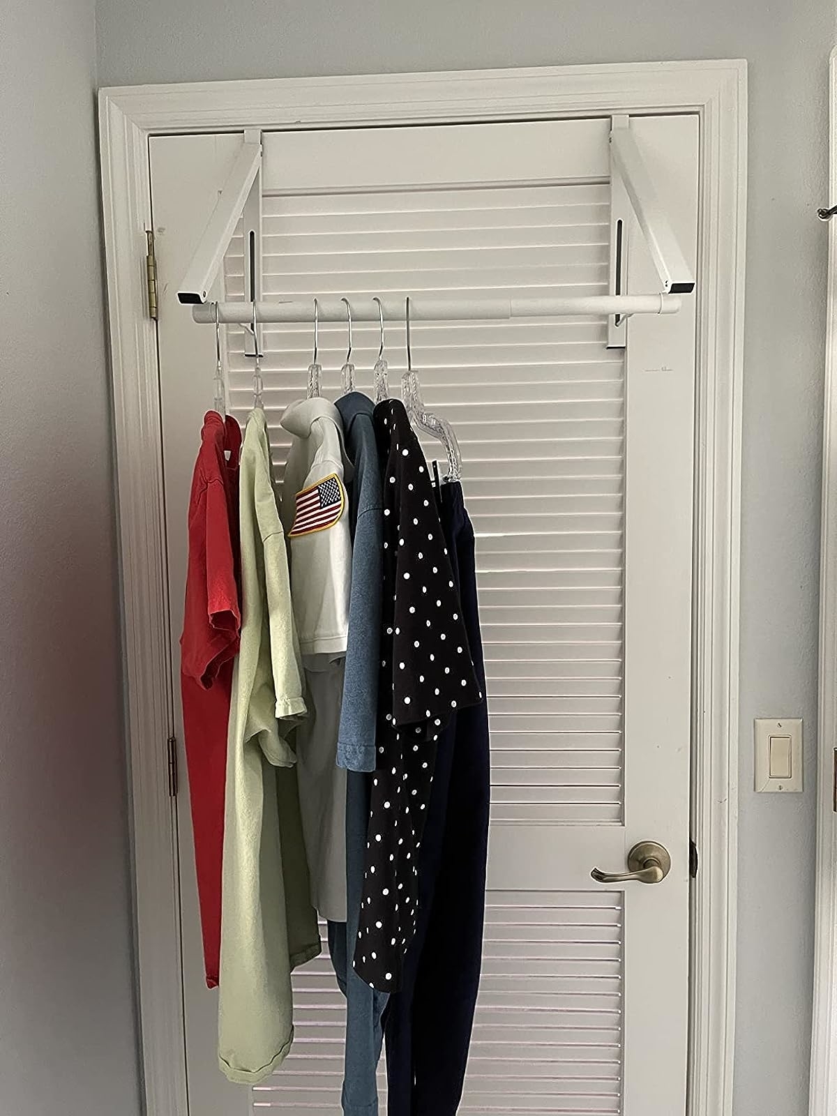 a reviewer photo of the retractable hanger on their closet
