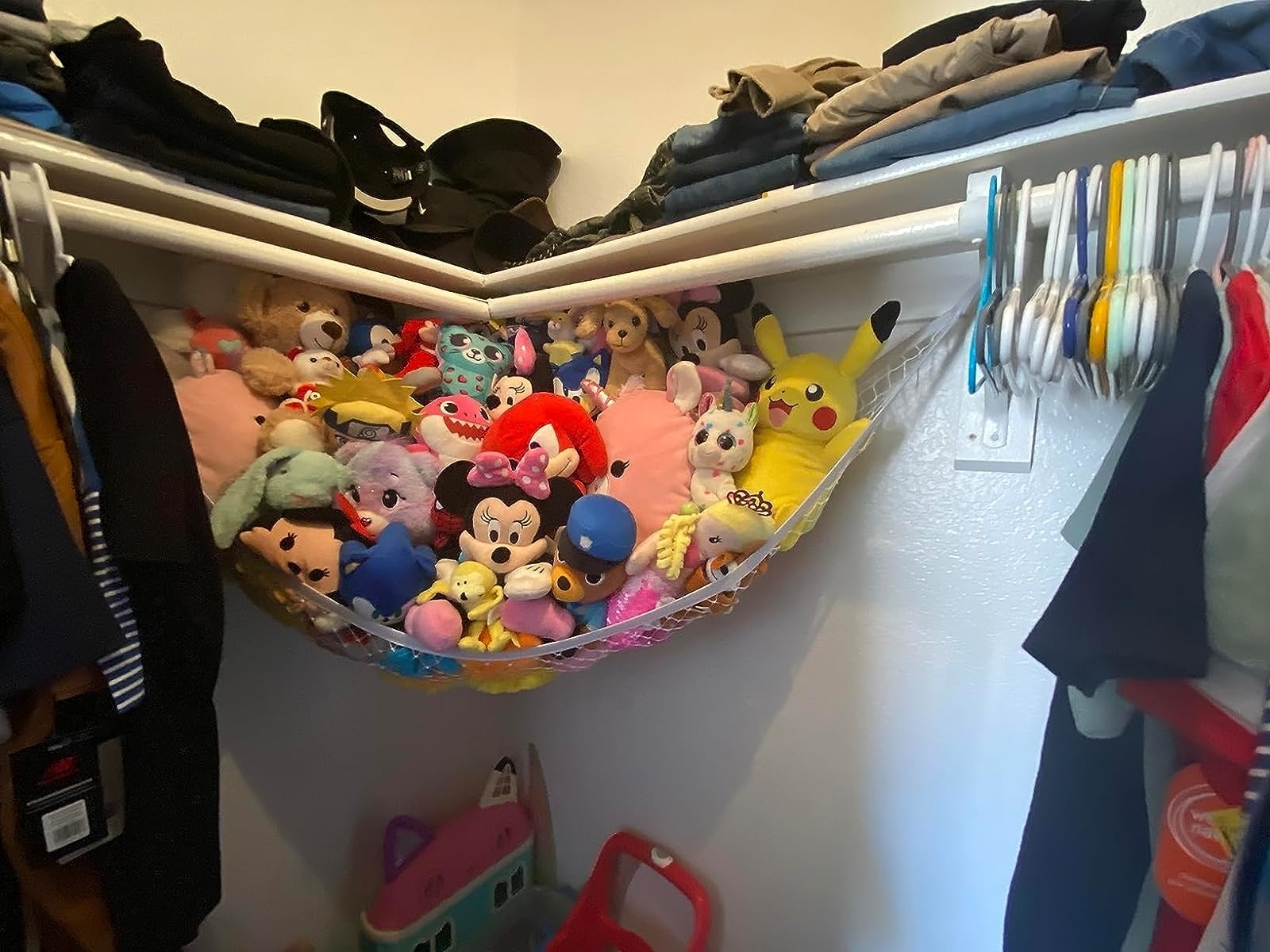 Reviewer image of stuffed animals in a pink hammock hanging in a closet corner