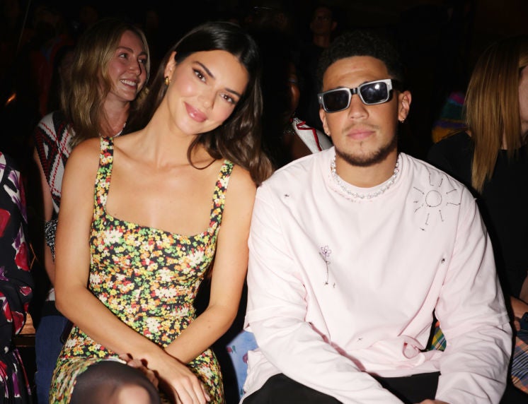 Kendal and Devin, who&#x27;s wearing sunglasses, sitting next to one another at an event